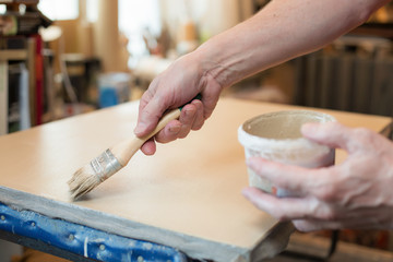 An artist priming canvas