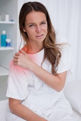 Fototapeta premium Woman covering painful shoulder