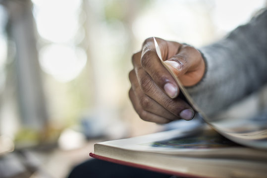 Close up of a man's hand flipping through the pages of a book.