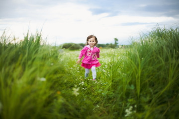 Naklejka na ściany i meble beautiful carefree girl playing outdoors in field