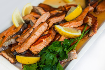 Stakes from a salmon with lemon on a plate