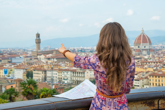Young woman with map pointing on panoramic view of florence