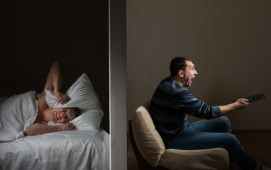 Man at night can't fall asleep because of the noisy neighbor