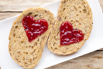 Grain slice of bread with jam heart shape.