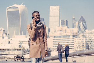 Young man talking on mobile with London city on background