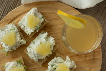 Farmer cheese sandwiches with pineapple and juice on wooden plat