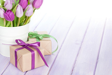 Purple tulip bouquet and gift box on wooden table