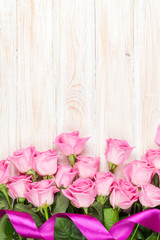 Fototapeta na wymiar Pink roses bouquet over wooden table