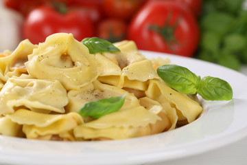 Italienische Nudeln Tortellini mit Tomaten und Basilikum auf Tel