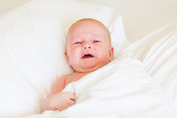 Peaceful newborn baby lying on a bed sleeping