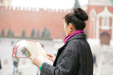 Young beautiful asian girl holding a tourist map of Moscow
