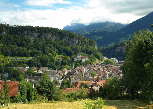 Panorama of Feldkirch, Austria, showcasing the historic town and Schattenburg Castle nestled in a lush valley. 
