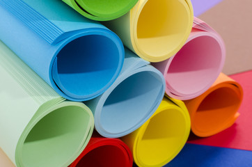 Roles of color paper piled.Stack of paper on color background.