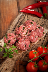 Raw meatballs on a chopping board
