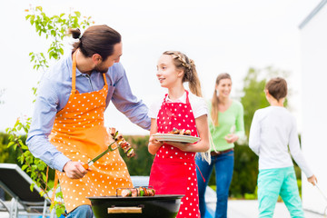 Father and daughter barbecue together