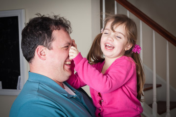 little girl being silly and  playing with her dad