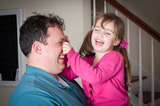 Little Girl Being Silly And  Playing With Her Dad