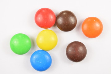 Colorful candies spread on white background.
