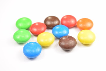 Colorful candies spread on white background.