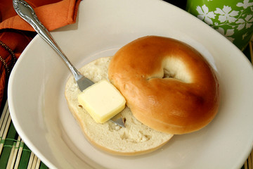 A bagel with a pat of butter 