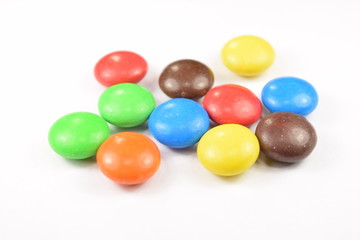 Colorful candies spread on white background.