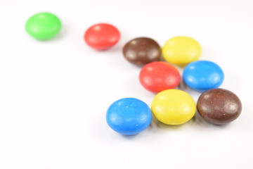 Colorful candies spread on white background.