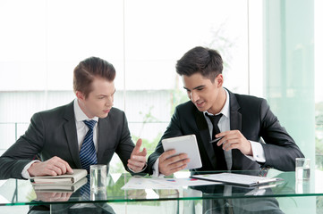 Two businessman using tablet in meeting