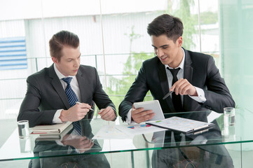 Two businessman using tablet in meeting