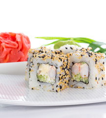Sushi roll on white plate with ginger and wasabi