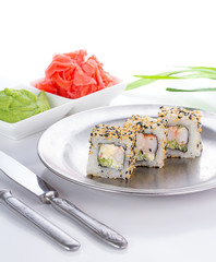 Sushi roll on white plate with ginger and wasabi