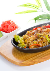 Udon with seafood and vegetables over white background