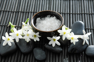 Fototapeta na wymiar SPA setting with white flower and zen stone,salt in bowl