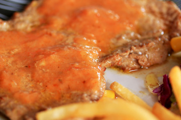 Steaks, pork, french fries with salad.