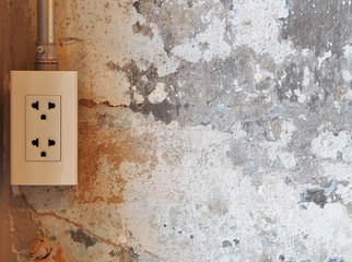 Electric plug on grunge cement wall background. For copy space.