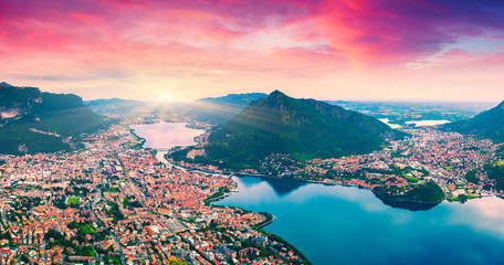 Panele Szklane Podświetlane  Kolorowy letni wschód słońca nad miastem i jeziorem Lecco