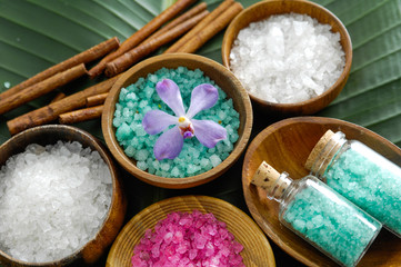 colorful salt in wooden bowl with cinnamon, orchid,salt in glass on banana leaf 