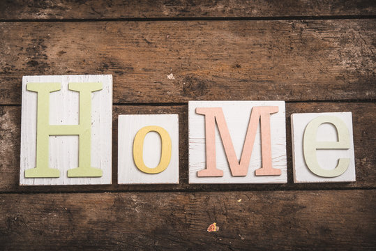 Home sweet home, wooden text on vintage board background 