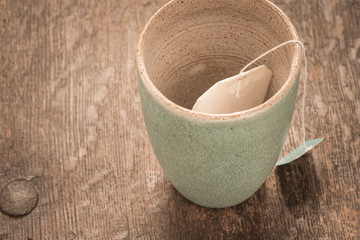 Empty teacup with teabag on rustic wooden table