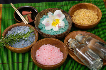 Fototapeta na wymiar colorful sea salt ,flower, in wooden bowl with orchid on green mat 