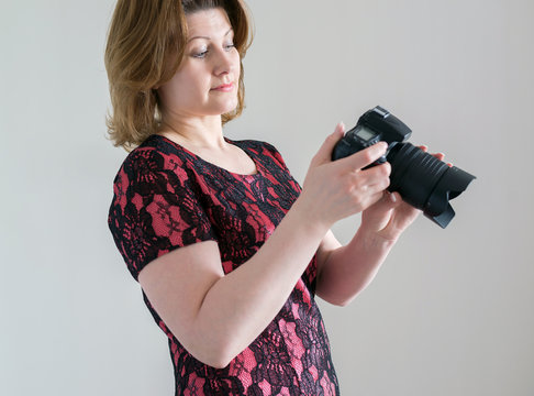 Woman with a camera on  light background
