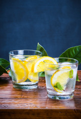 Glasses with drink, slices lemon and mint.