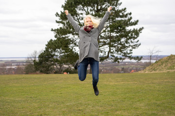 Blond girl jumping joyfully
