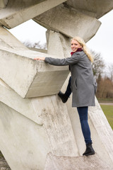 Blond girl in winter coat climbing