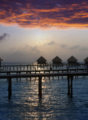 Silhouette of lodges in the sea at sunset. Maldives