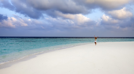 Fototapeta na wymiar The woman runs on sea coast, Maldives