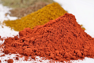 Heaps of different dry spices on a white