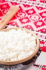curd in brown bowl on the Ukrainian rushnyk
