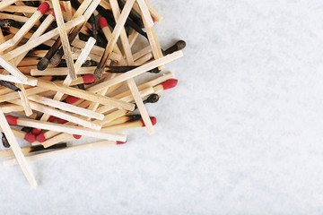 Pile of burnt and whole matches on light background