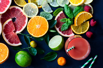 Fresh citrus slices and juice on black background top view - obrazy, fototapety, plakaty
