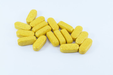 Yellow medical pills on white background